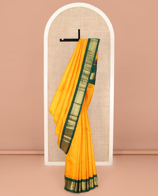 Yellow Kanchipuram Silk Saree, Sparsely Sparkled with Zari Buttas on Its Body, Complemented by a Contrast One-Sided Korvai Border of Thilakam Mokku, Banaras, Muthu, and Kamalam Designs, Pallu Features Zari Designs, and Comes Without a Blouse