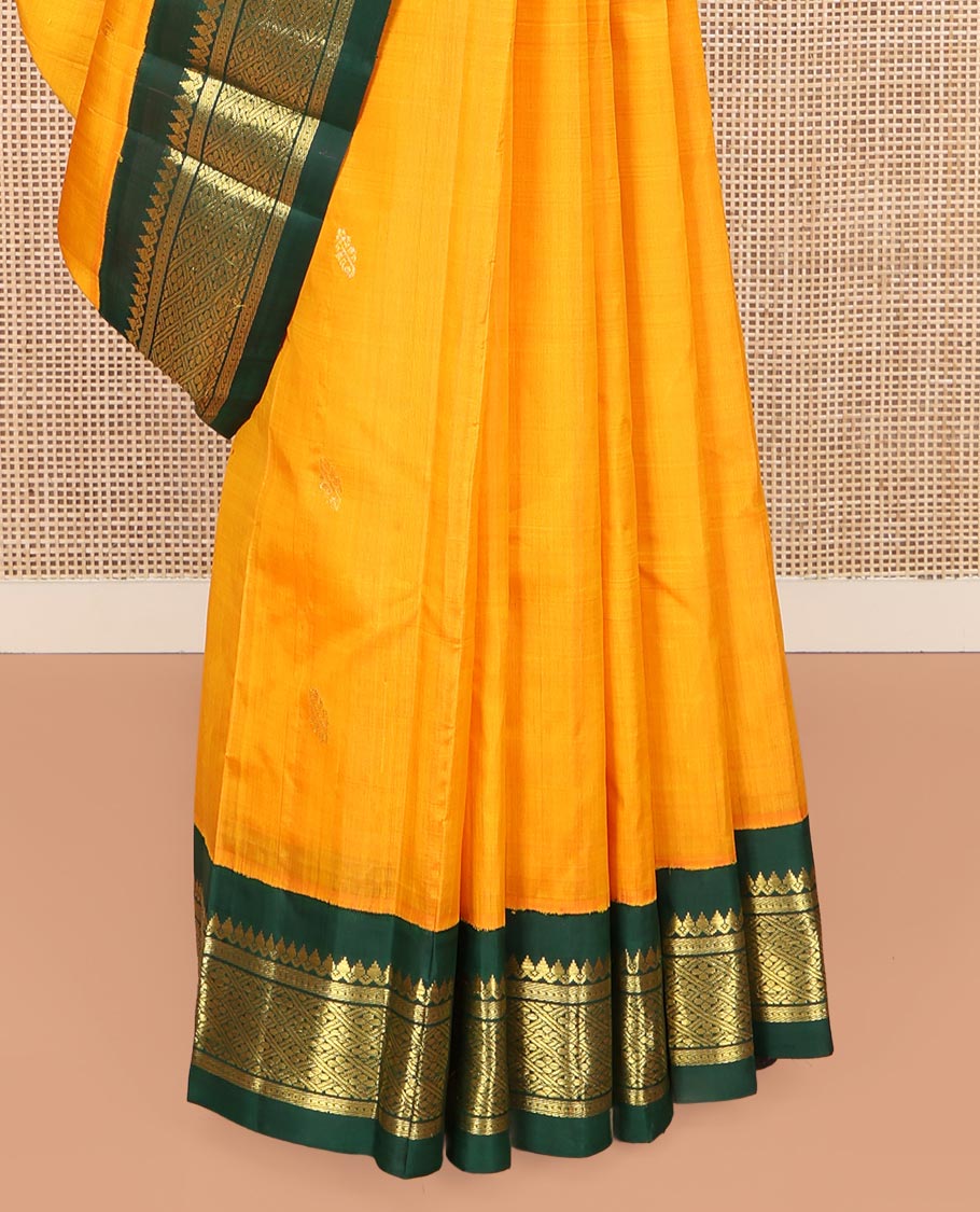 Yellow Kanchipuram Silk Saree, Sparsely Sparkled with Zari Buttas on Its Body, Complemented by a Contrast One-Sided Korvai Border of Thilakam Mokku, Banaras, Muthu, and Kamalam Designs, Pallu Features Zari Designs, and Comes Without a Blouse