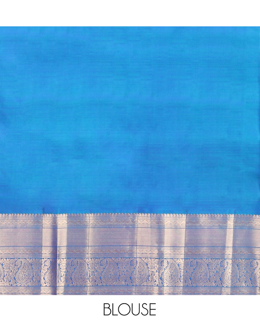 Blue Vasundhara Silk Saree, Mesmerized with Zari Buttas on Its Body, Highlighted by a Zari Border of Manga Mokku, Muthu, and Arumbu Manga Designs, Pallu Steeped with Leaf Designs, and Paired with a Matching Blouse