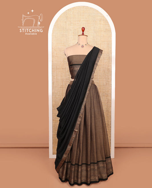 Brown plain cotton half-saree with traditional zari bordered skirt, a matching blouse, and a contrast traditional bordered dhavani