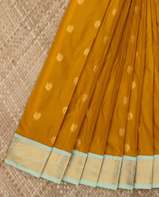 Mustard Budget Silk Saree Adorned with Peacock Chakram Buttas, Complemented with a Contrast Traditional Zari Peacock Chakram Design Border, Pallu of Zari Design Weave, and Paired with a Contrast Blouse