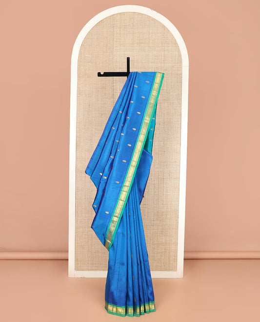 Blue Kanchipuram Silk Saree Elegantly Designed with Zari Buttas All Over Its Body, Complemented by a Contrast One-Sided Border of Banaras, and Mayil Kann Designs, Pallu of Zari Motifs, and Comes Without a Blouse