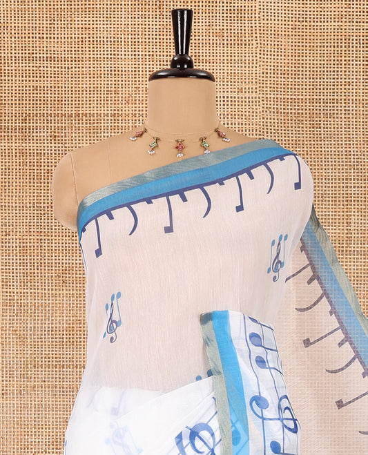 White and blue musical note motifs printed Chanderi cotton saree, zari piping border, geometric printed pallu, and a unique motifs printed blouse