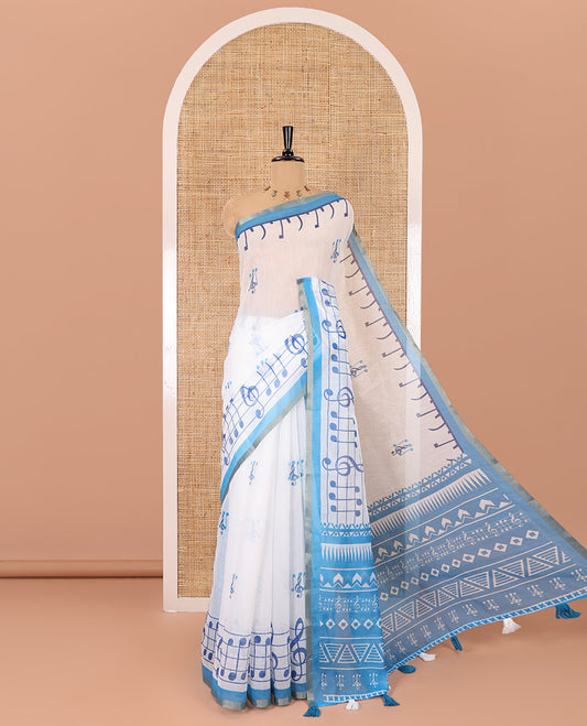 White and blue musical note motifs printed Chanderi cotton saree, zari piping border, geometric printed pallu, and a unique motifs printed blouse