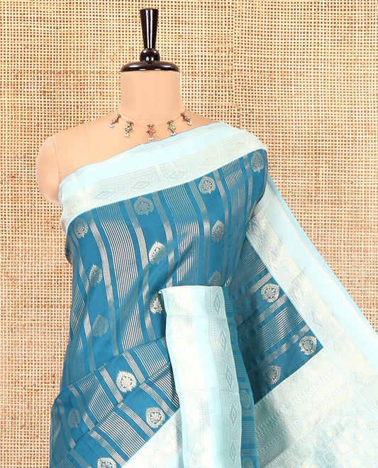 Peacock Blue Litchi Saree, Elevated with Vaira Oosi Stripes and Zari Buttas on Its Body, Complemented by a Contrast Rettai Pettu Traditional Zari Design Border, an Intricately Designed Pallu, and Paired with a Contrast Blouse