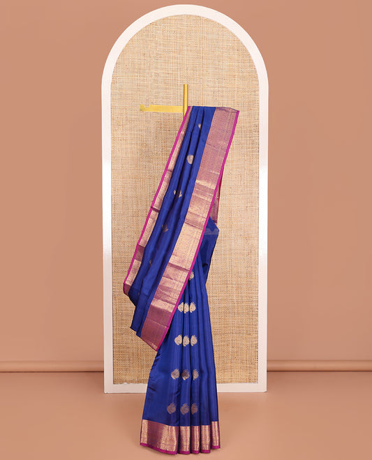 Blue Vasundhara Lite-Silk Mix Saree, Adorned with Zari Buttas, Complemented by Contrast Border Featuring Thilakam Mokku, Kodi Visiry, Muthu, Laddu Kamalam, and Mayil Designs, Grandly Pallu of Scallop Designs, and Paired with a Contrast Blouse