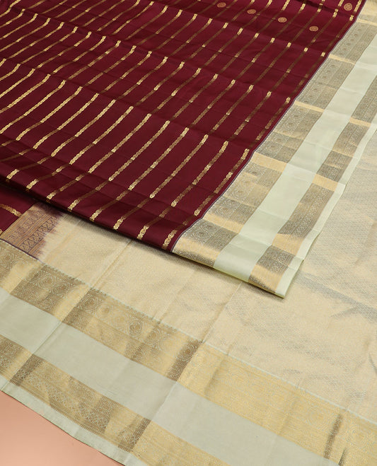 Maroon Vasundhara Silk Saree Richly Detailed with Zari Buttas and Zari Designs, Complemented by a Contrast Rettai Pettu Border of Round Mayil Designs, Subtly Designed Pallu of Floral Jaal Designs, and a Contrast Blouse