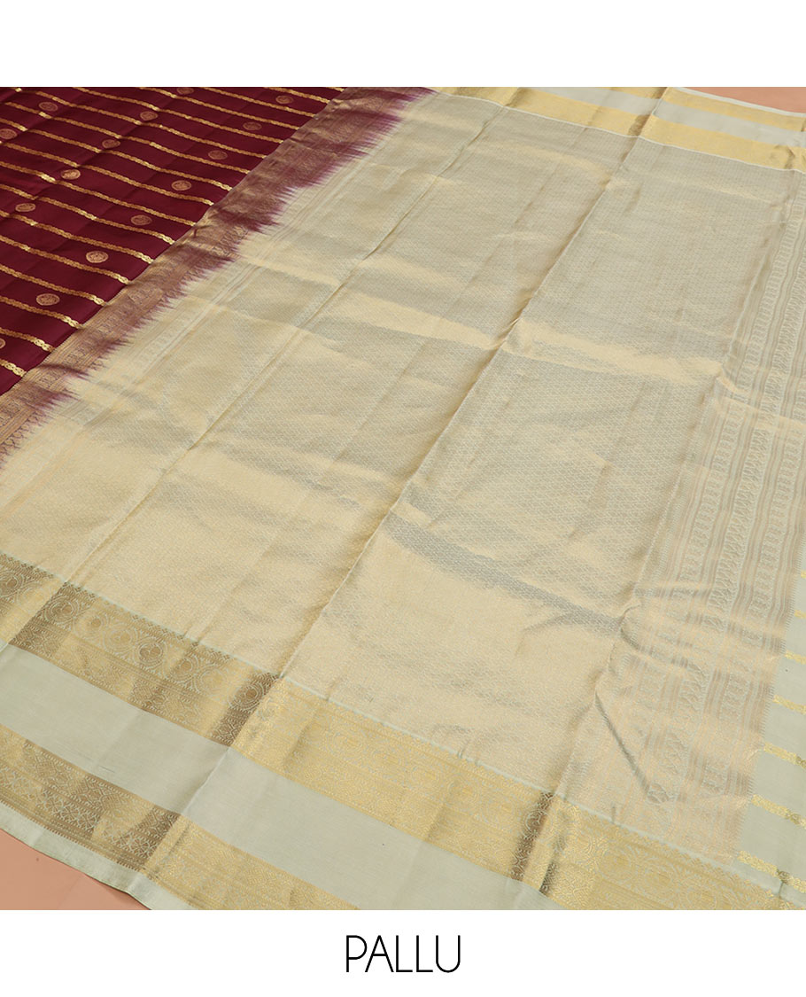 Maroon Vasundhara Silk Saree Richly Detailed with Zari Buttas and Zari Designs, Complemented by a Contrast Rettai Pettu Border of Round Mayil Designs, Subtly Designed Pallu of Floral Jaal Designs, and a Contrast Blouse