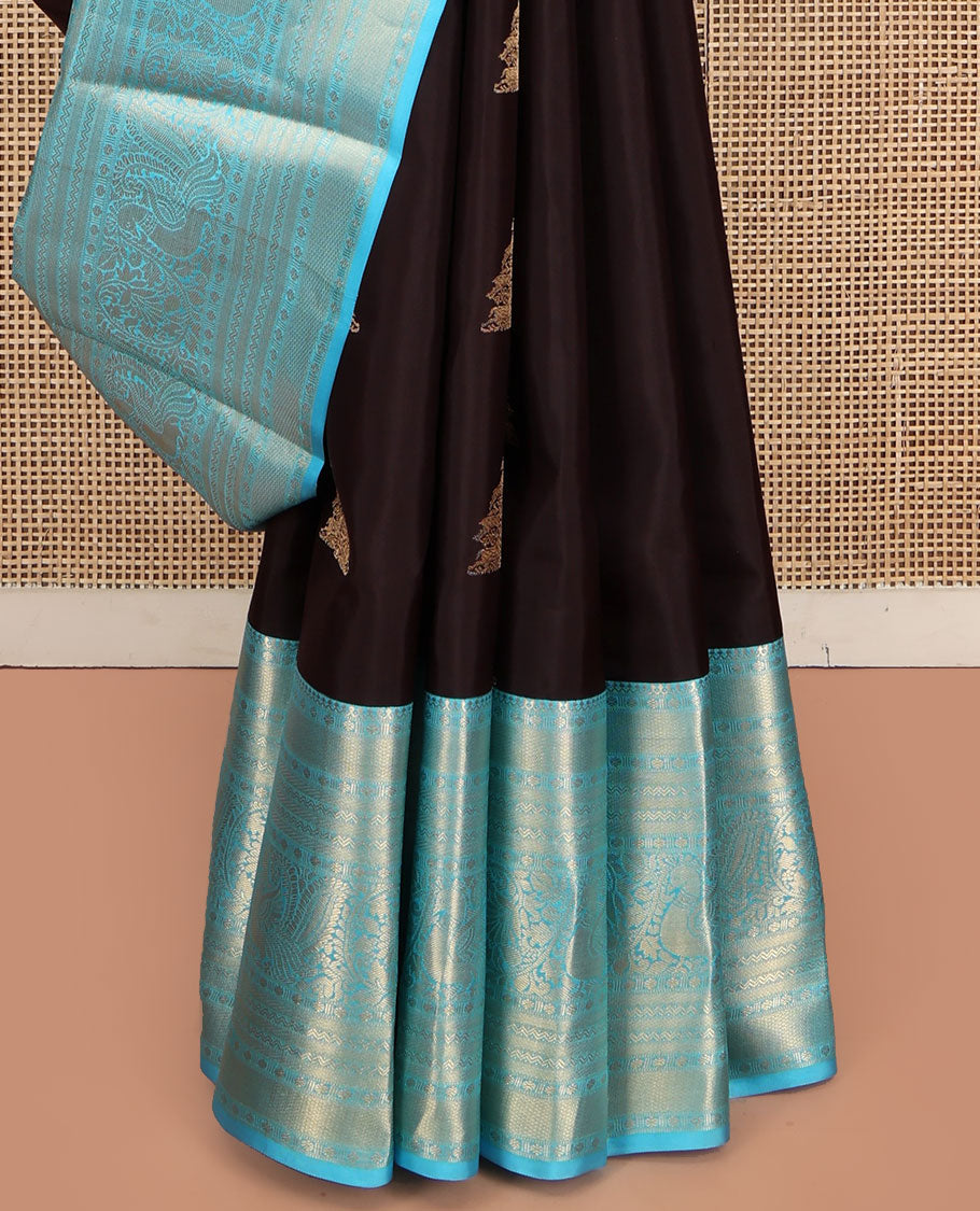 Brown Vasundhara Silk Saree, Elegantly Highlighted with Zari Buttas All Over Its Body, Complemented by Contrast Border of Salngai, Rettai Neli, Kodi Mayil, and Mayil Kann Designs, Grandly Embellished Pallu, and Paired with a Contrast Blouse