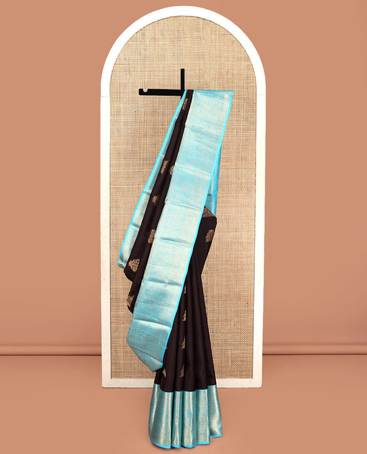 Brown Vasundhara Silk Saree, Elegantly Highlighted with Zari Buttas All Over Its Body, Complemented by Contrast Border of Salngai, Rettai Neli, Kodi Mayil, and Mayil Kann Designs, Grandly Embellished Pallu, and Paired with a Contrast Blouse