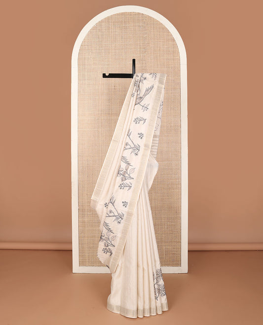 Cream printed tussar saree mirrors the bird on the floral branches design, has a zari border & zari striped pallu
