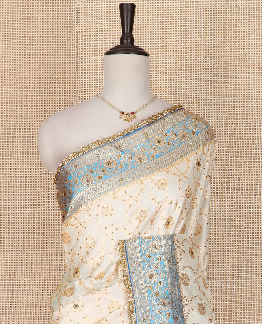 Cream Art Vastrakala Silk Saree Enthralled with Floral Jaal Jacquard with Stone Work All Over Its Body, Complemented by a Contrast Floral Creeper Zari Stone Work Border, Pallu Detailed in Zari and Stone Work, and Paired with a Contrast Blouse