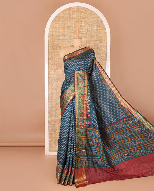 Green chevron striped patola saree, contrast traditional zari and patola printed border, patola printed pallu, and a contrast blouse