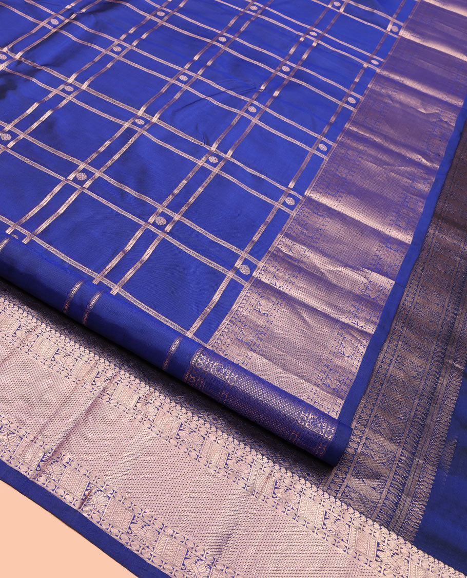 Blue Kanchipuram Silk Saree, Delicately Woven with Zari Buttas and Checked Design All Over Its Body, Highlighted by Zari Border of Manga Mokku, Paisa, Mayil, and Mayil Kann Designs, a Grand Jaal Pallu, and Paired with a Matching Blouse