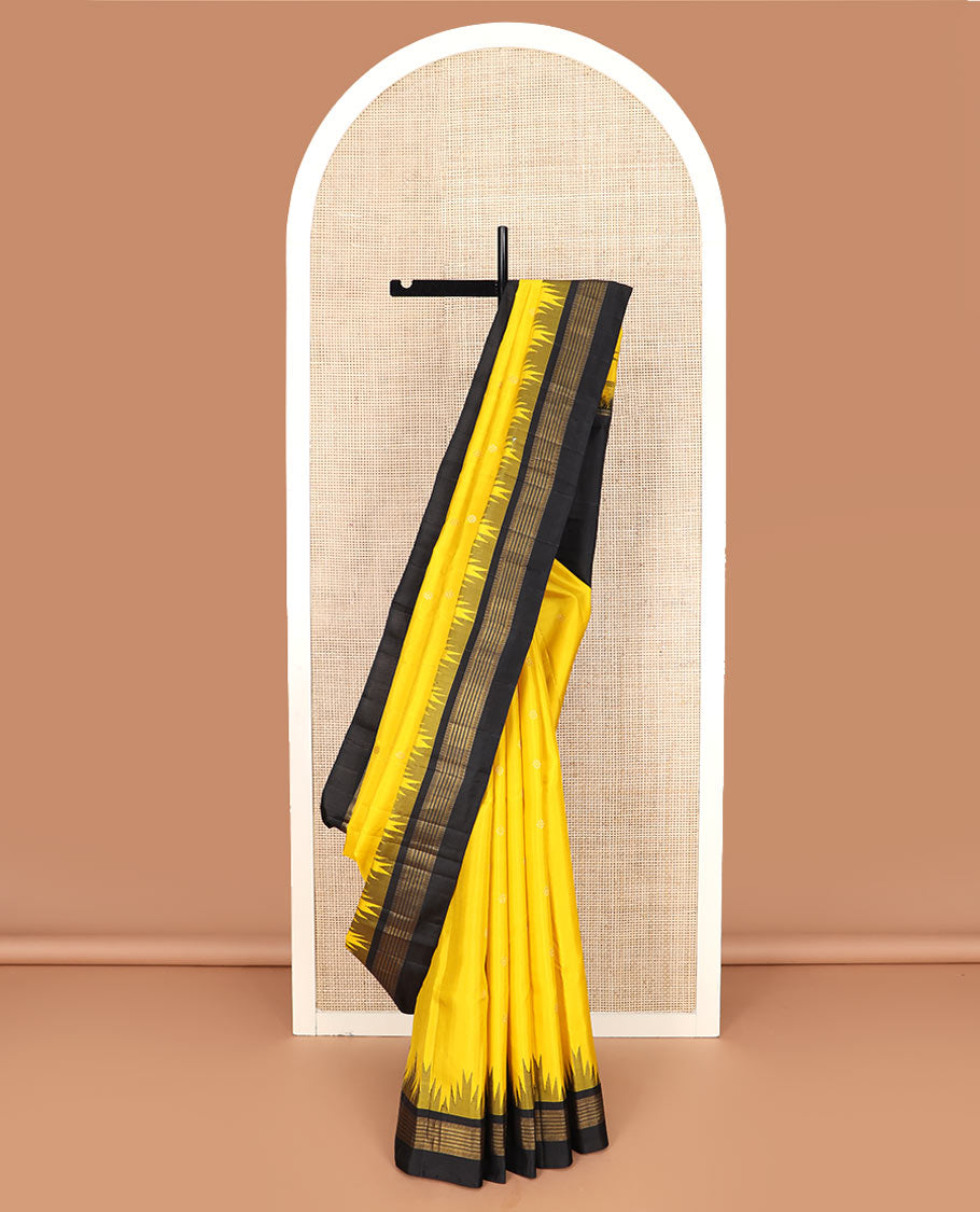 Yellow zari buttas Kanchipuram silk saree, contrast thazampoo rekku zari border, and pallu features kamalam designs