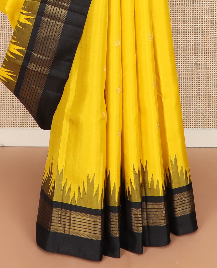 Yellow zari buttas Kanchipuram silk saree, contrast thazampoo rekku zari border, and pallu features kamalam designs