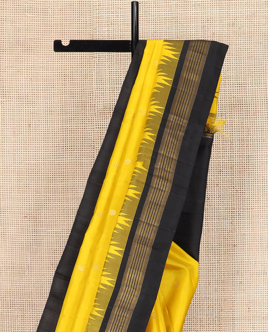 Yellow zari buttas Kanchipuram silk saree, contrast thazampoo rekku zari border, and pallu features kamalam designs