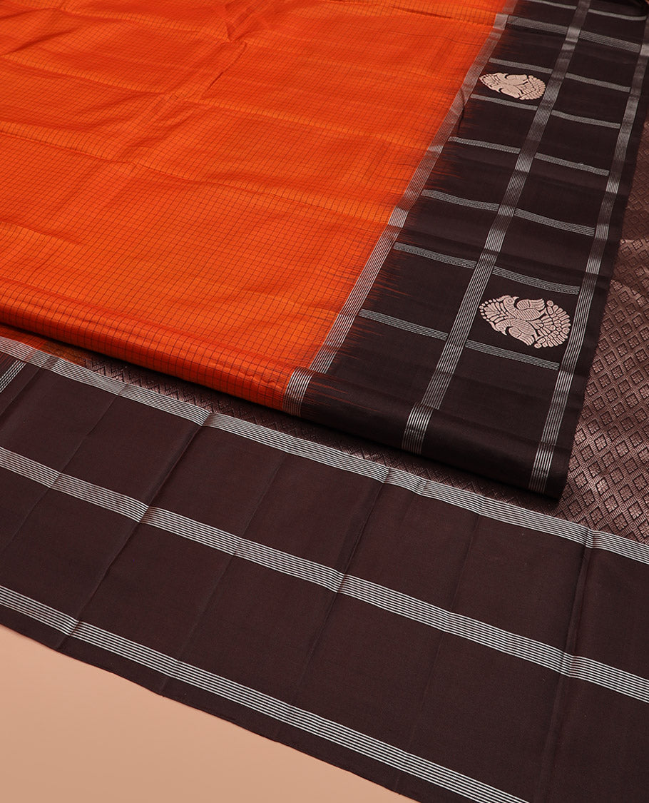 Orange Kanchipuram Silk Saree Sparsely Sparkled Checks on Its Body, Complemented by a Contrast Border of Iruthalai Pakshi Butta Enclosed Checks, Gleaming Pallu of Jaal Designs, and Paired with a Contrast Blouse