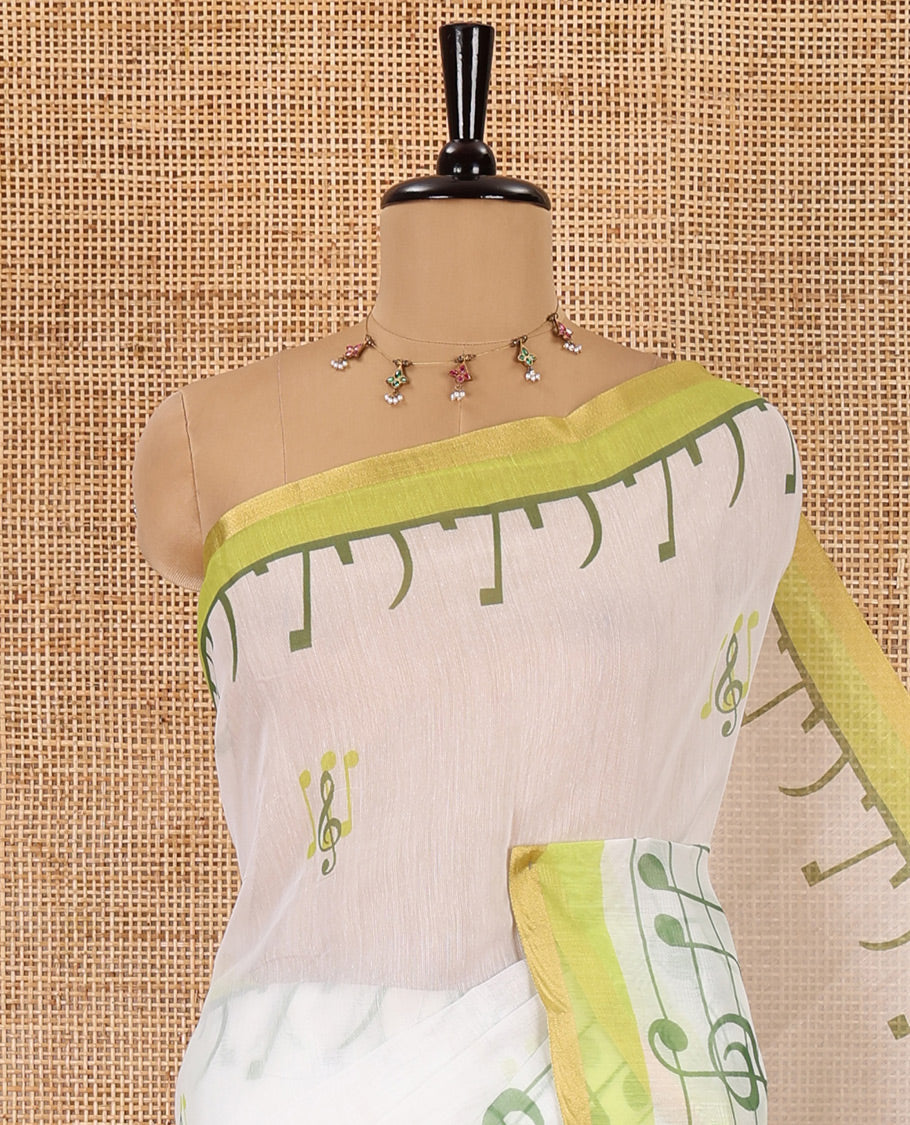 White and green musical note motifs printed Chanderi cotton saree, zari piping border, geometric printed pallu, and a unique motifs printed blouse