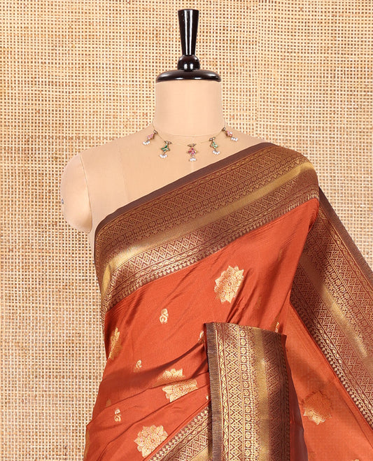 Rust Orange Kanchi Silk Saree, Beautified with Floral Zari Buttas All Over Its Body, Complemented by a Contrast Border of Traditional Zari Designs, Majestically Detailed Pallu, and Paired with a Contrast Blouse