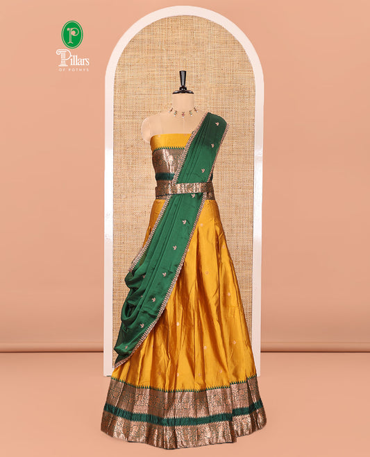 Yellow-Green Semi-Banarasi Half-Saree Subtly Sparkled with Zari Buttas on Its Skirt, Complemented by a Contrast Traditional Zari Temple Rettai Pettu Border, Paired with a Matching Blouse, and a Satin Georgette Embroidered Scallop Dhavani