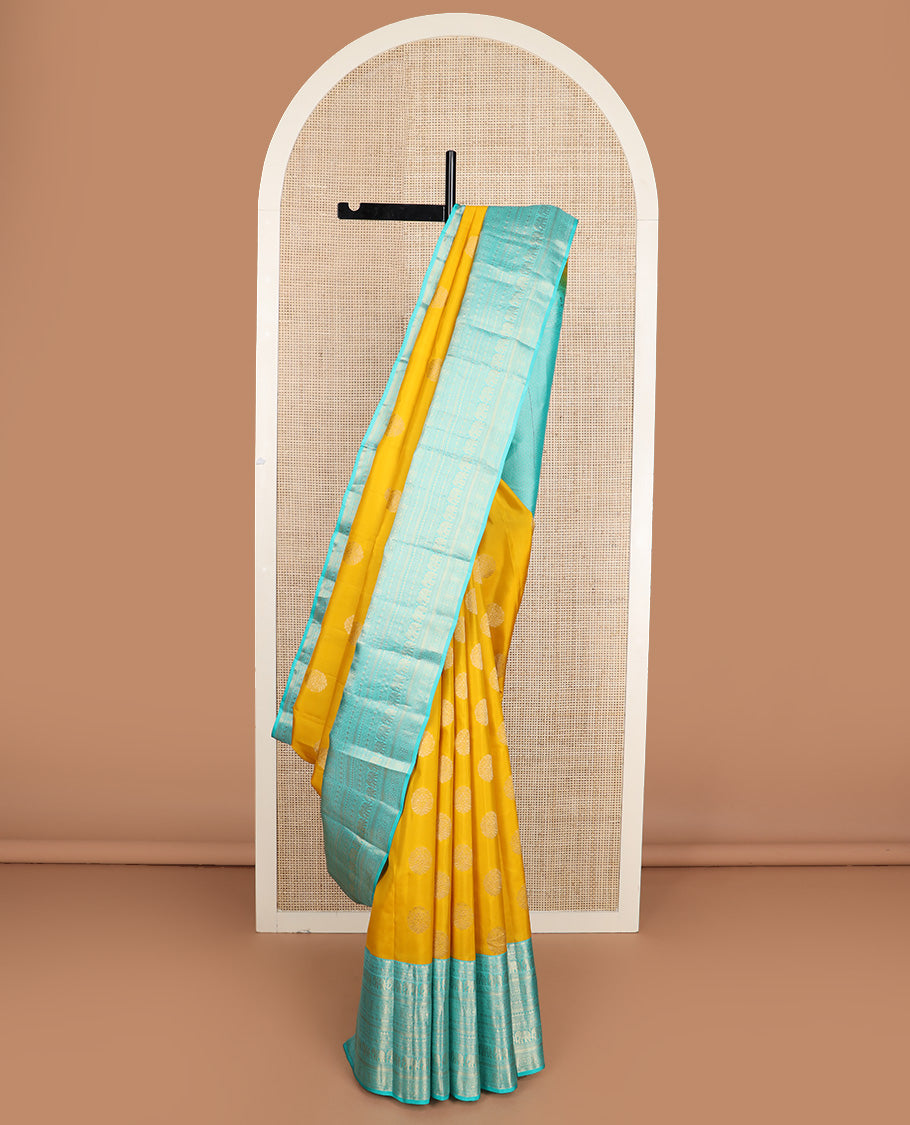 Yellow zari buttas silk saree, contrast border of thilakam mokku, poun, yaanai, chakram, and mayil kann designs, and jaal pallu