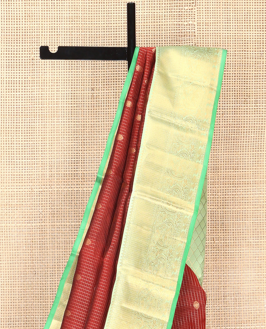 Brown Vasundhara Silk Saree, Detailed with Mayil and Chakram Buttas Enclosed Checks, Complemented by Contrast Border of Rekku, Mayil Kann, and Mayil Manga Designs, Grand Jaal Pallu and Paired with a Contrast Blouse