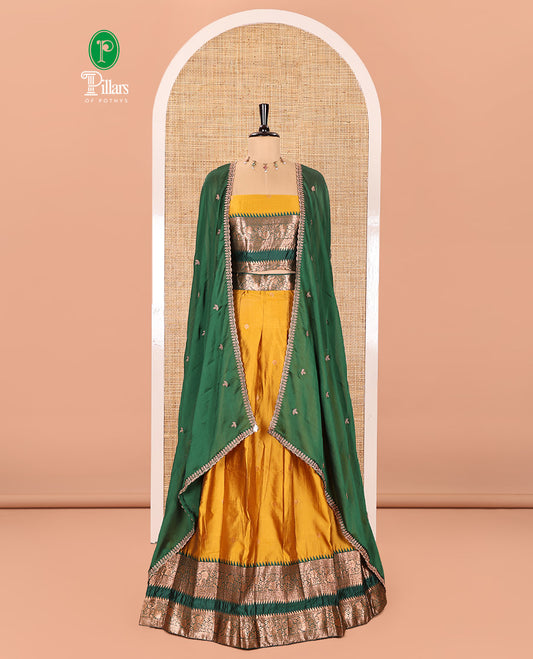 Yellow-Green Semi-Banarasi Half-Saree Subtly Sparkled with Zari Buttas on Its Skirt, Complemented by a Contrast Traditional Zari Temple Rettai Pettu Border, Paired with a Matching Blouse, and a Satin Georgette Embroidered Scallop Dhavani