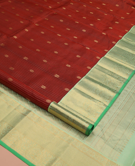 Brown Vasundhara Silk Saree, Detailed with Mayil and Chakram Buttas Enclosed Checks, Complemented by Contrast Border of Rekku, Mayil Kann, and Mayil Manga Designs, Grand Jaal Pallu and Paired with a Contrast Blouse