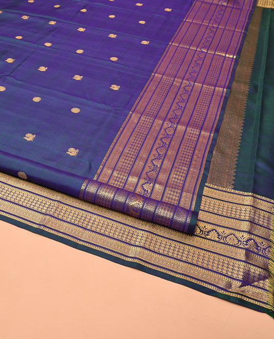 Blue Kanchipuram Silk Saree, Embellished with Mayil and Chakram Buttas All Over Its Body, Highlighted by a Zari Border of Traditional Designs, Pallu Steeped with Traditional Designs, and Paried with a Matching Blouse