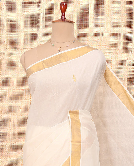 Cream Kerala Cotton Saree, Showcasing Zari Buttas All Over Its Body, a Zari Bavanji Border, Pallu of Peacock Designs, and Paired with a Matching Blouse