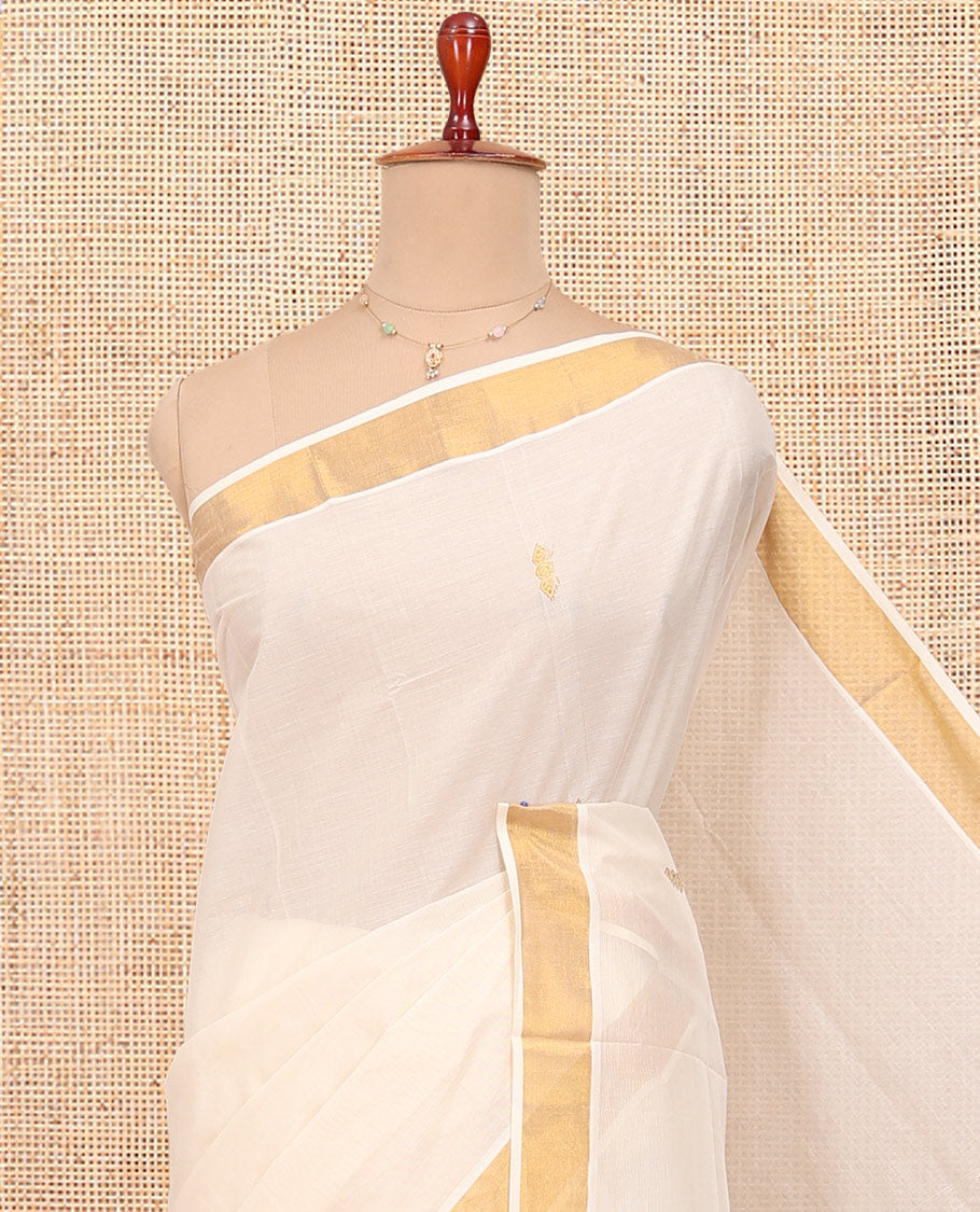 Cream Kerala Cotton Saree, Showcasing Zari Buttas All Over Its Body, a Zari Bavanji Border, Pallu of Peacock Designs, and Paired with a Matching Blouse