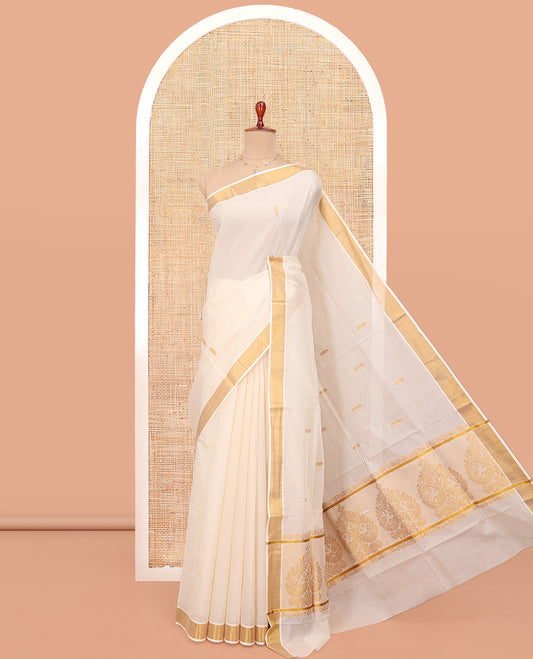 Cream Kerala Cotton Saree, Showcasing Zari Buttas All Over Its Body, a Zari Bavanji Border, Pallu of Peacock Designs, and Paired with a Matching Blouse