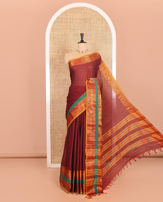 Maroon Plain Mercerised Cotton Saree Artfully Detailed with a Contrasting Rettai Pettu Border Featuring Peacock Motifs in Zari, a Subtly Striped Pallu, and a Matching Blouse