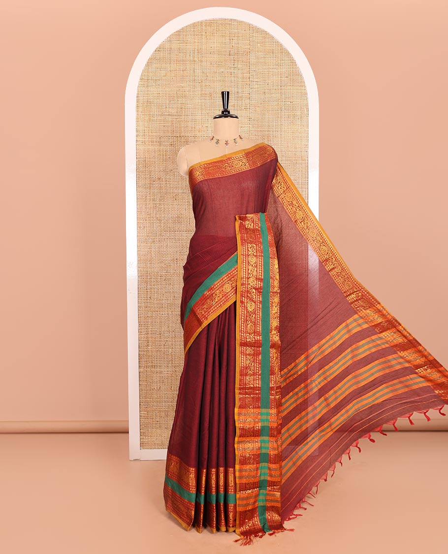 Maroon Plain Mercerised Cotton Saree Artfully Detailed with a Contrasting Rettai Pettu Border Featuring Peacock Motifs in Zari, a Subtly Striped Pallu, and a Matching Blouse