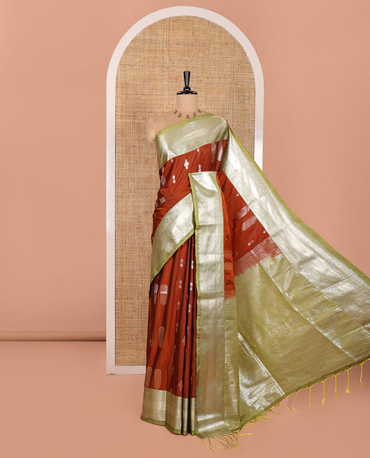 Rust Orange Elite Soft Silk Saree Enriched with Zari Buttas All Over Its Body, Complemented by Contrast Floral Creeper Zari Border, Scintillating Pallu of Intricate Designs, and Paired with a Contrast Blouse