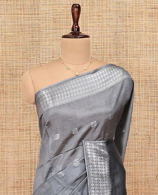 Grey Banana Pith Saree, Subtly Sparkled with Buttas All Over Its Body, Highlighted by Self-Border of Temple and Rudraksham Motifs, Pallu Steeped with Stripes and Buttas, and Paired with a Matching Blouse