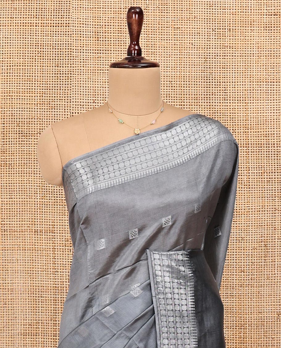 Grey Banana Pith Saree, Subtly Sparkled with Buttas All Over Its Body, Highlighted by Self-Border of Temple and Rudraksham Motifs, Pallu Steeped with Stripes and Buttas, and Paired with a Matching Blouse