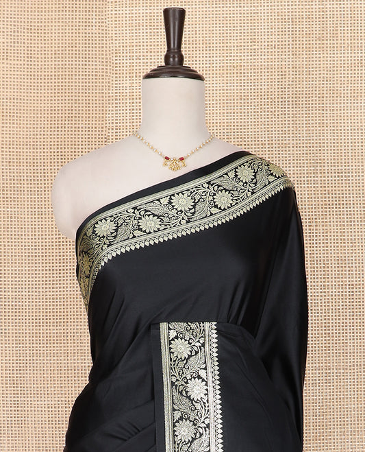 Inky Black Semi-Banaras Satin Saree, Subtly Sparkled Border of Floral Creeper Designs, Pallu Beautified with Thilak Motifs in Zari, and Paired with a Matching Blouse