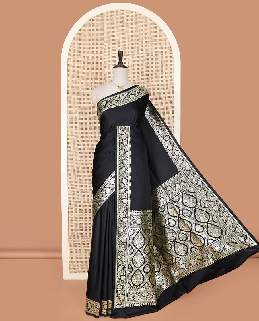 Inky Black Semi-Banaras Satin Saree, Subtly Sparkled Border of Floral Creeper Designs, Pallu Beautified with Thilak Motifs in Zari, and Paired with a Matching Blouse