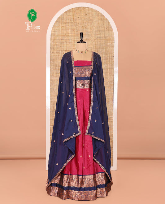 Pink-Blue Semi-Banarasi Half-Saree Subtly Sparkled with Zari Buttas on Its Skirt, Complemented by a Contrast Traditional Zari Temple Rettai Pettu Border, Paired with a Matching Blouse, and a Satin Georgette Embroidered Scallop Dhavani