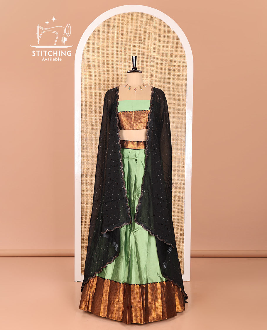 Pista Green Taffeta Silk Half-Saree Featuring a Plain Skirt, Elevated with a Contrast Traditional Zari Design Border, Paired with a Matching Blouse, and a Georgette Scallop-Bordered Stone Work Dhavani