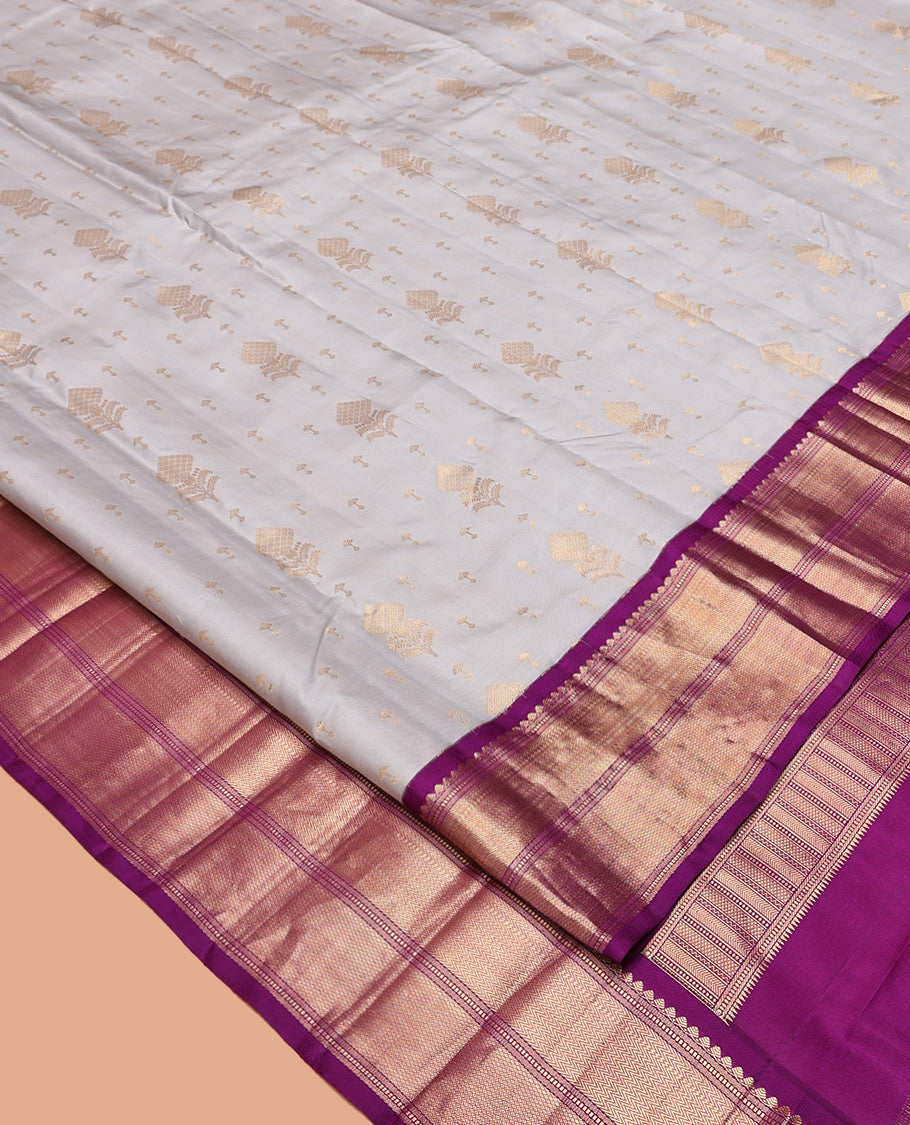 Grey Vasundhara Silk Saree, Adorned with Zari Buttas All Over Its Body, Complemented by a Contrast Border of Thilakam Mokku, Muthu, Vanki, and Mayil Kann Designs, Grand Manga Design Pallu, and Paired with a Contrast Blouse