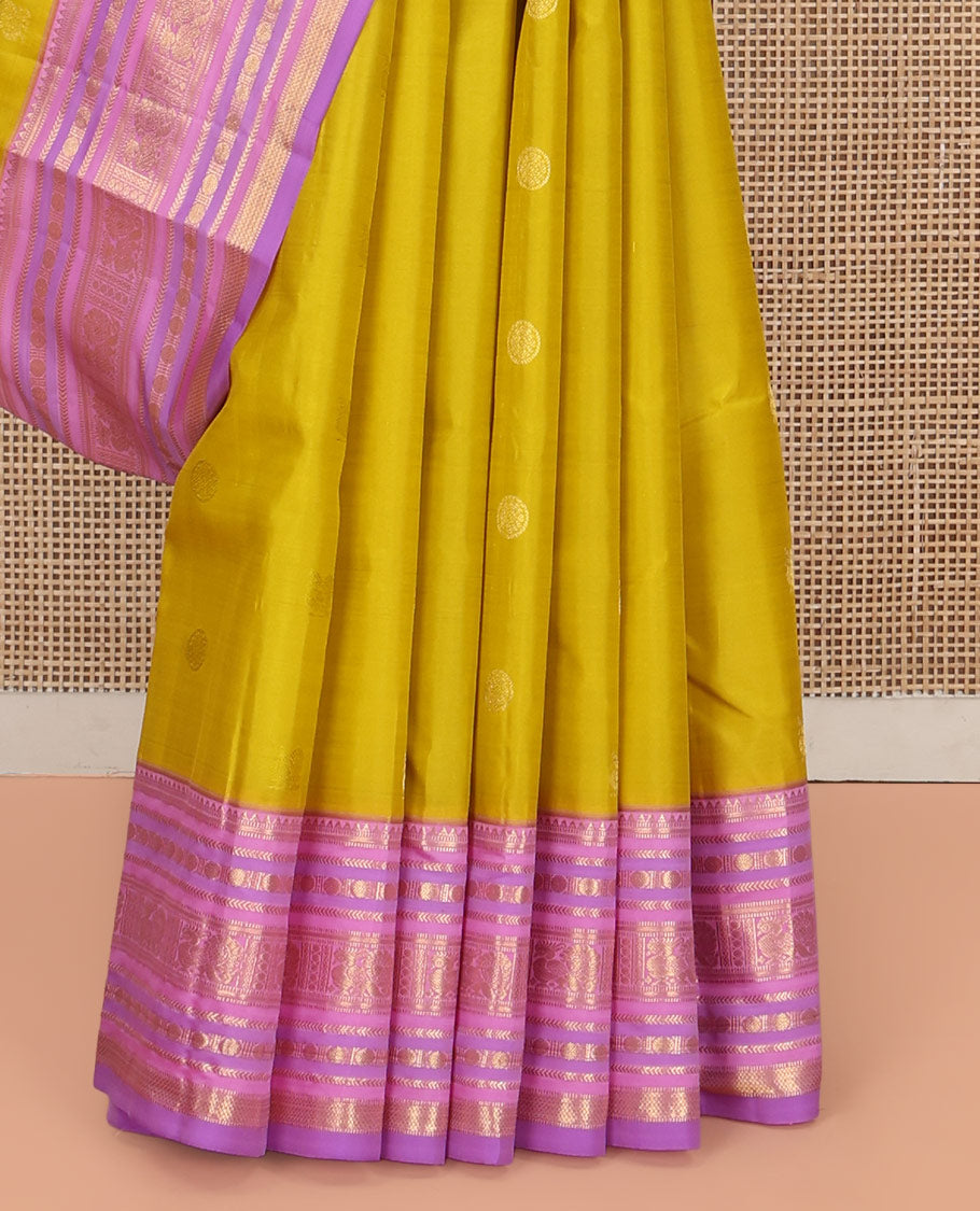 Green Vasundhara Silk Saree, Sparsely Threaded with Zari Buttas All Over Its Body, Complemented by a Contrast Border of Rekku, Muthu, Kathir, Poun, Mayil, and Mayil Kann Designs, Grandly Decked Up Pallu, and Paired with a Contrast Blouse