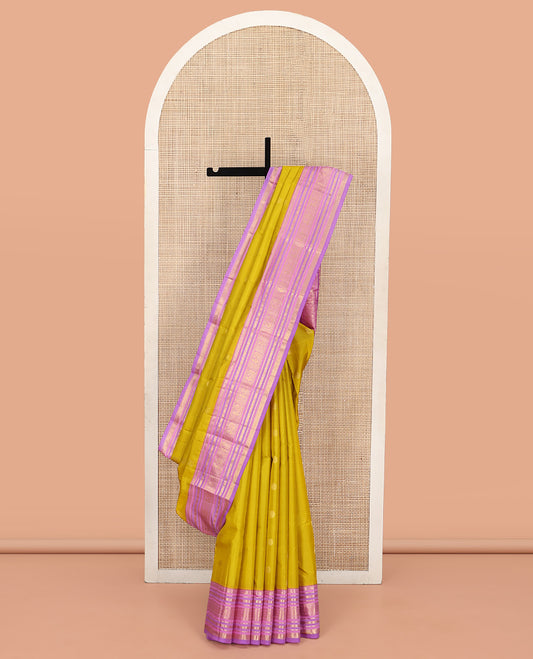 Green Vasundhara Silk Saree, Sparsely Threaded with Zari Buttas All Over Its Body, Complemented by a Contrast Border of Rekku, Muthu, Kathir, Poun, Mayil, and Mayil Kann Designs, Grandly Decked Up Pallu, and Paired with a Contrast Blouse