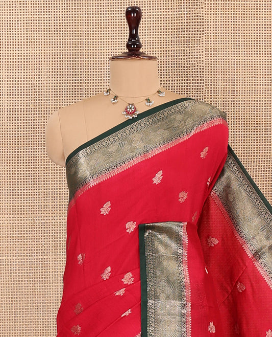 Red Assam Silk Saree Gracefully Embellished with Floral Zari Buttas, Complemented by Captivating Contrast Border Featuring Traditional Zari Designs, Gleaming Pallu of Zari Designs, and Paired with a Contrast Blouse