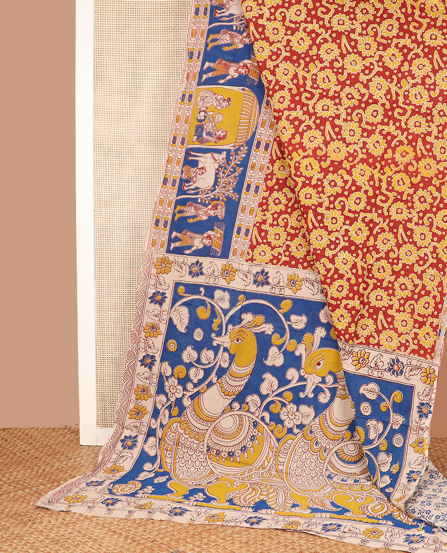 Red batik floral machine-printed cotton saree, contrast village-theme printed border, and pallu of Kalamkari peacocks