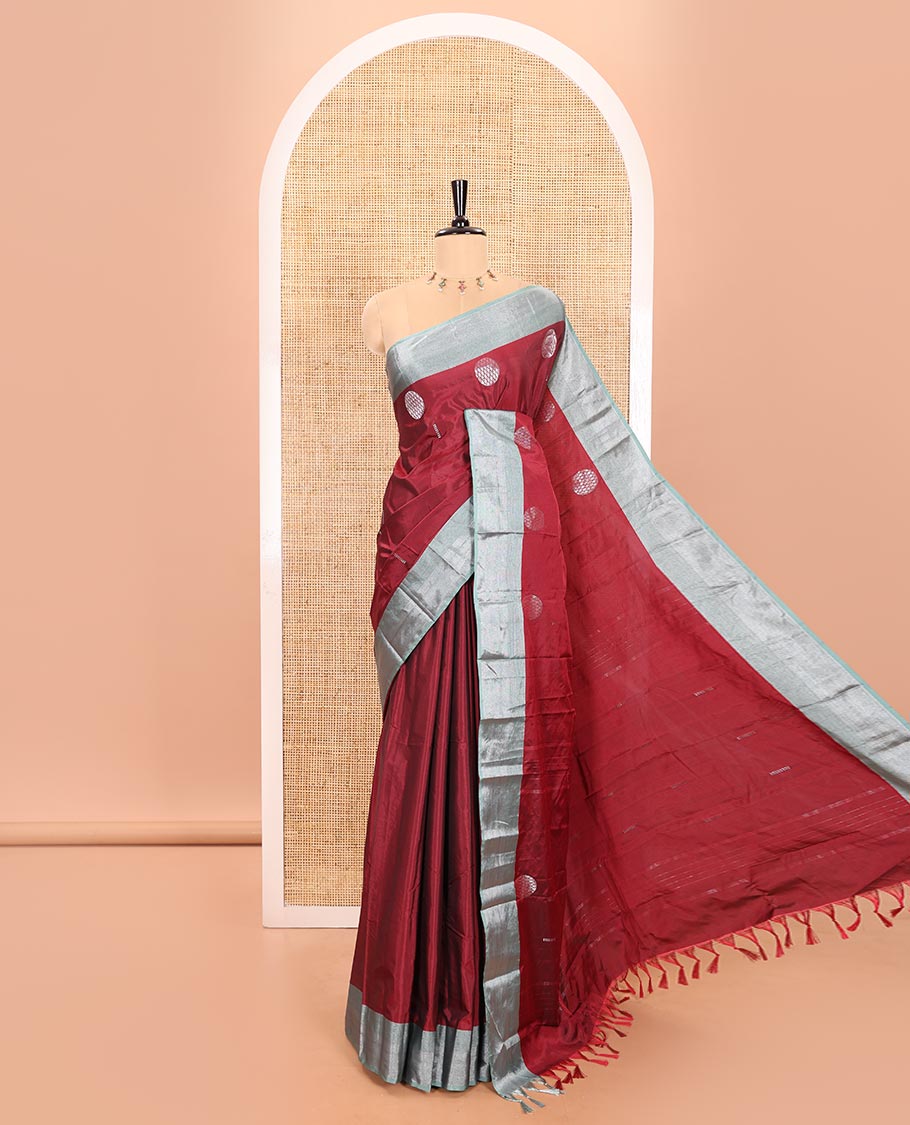 Cherry Red Semi-Soft Silk Saree Featuring Round Silver Zari Buttas Woven Across Its Body, Complemented by a Contrast Zari Design Border, Subtly Made Self-Pallu, and a Matching Blouse