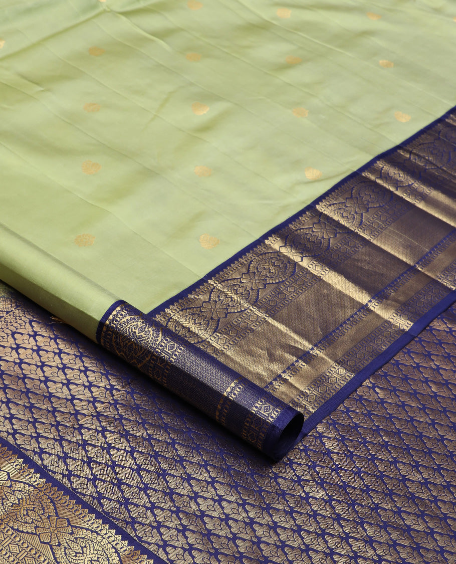 Green zari buttas silk saree, contrast border of rekku, muthu, kamalam, diamond, and mayil kann designs, and jaal pallu