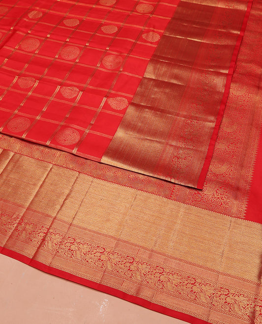 Red Vasundhara Silk Saree Artfully Woven with Zari Butta Enclosed Checks All Over Its Body, Highlighted by Zari Border of Rekku, Mayil Kann, Kathir, and Mayil Designs, a Grand Pallu of Jaal Designs, and Paired with a Matching Blouse